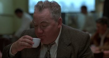 Movie still from “True Confessions” (1981), directed by Ulu Grosbard – A person drinking a cup of coffee; Close Up shot, Low angle