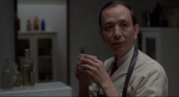 Movie still from “True Confessions” (1981), directed by Ulu Grosbard – A man holding a coffee cup in his hands; Close Up shot, Low angle