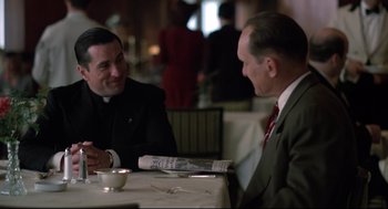 Movie still from “True Confessions” (1981), directed by Ulu Grosbard – Two men are sitting at a table and talking; Medium shot, Over the shoulder angle