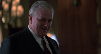 Movie still from “True Confessions” (1981), directed by Ulu Grosbard – An older man wearing a suit and tie smiling; Close Up shot, Low angle