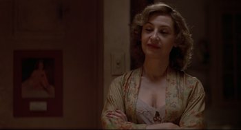 Movie still from “True Confessions” (1981), directed by Ulu Grosbard – A woman with her arms crossed in front of a mirror; Close Up shot, Over the shoulder angle