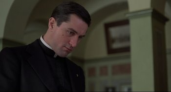 Movie still from “True Confessions” (1981), directed by Ulu Grosbard – A man wearing a priest's outfit looking down; Close Up shot, Low angle