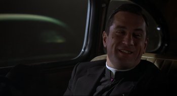 Movie still from “True Confessions” (1981), directed by Ulu Grosbard – A priest sitting in the back seat of a car; Close Up shot, Low angle