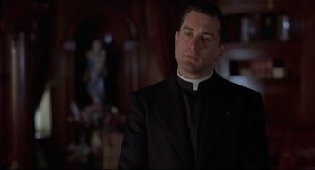 Movie still from “True Confessions” (1981), directed by Ulu Grosbard – A man wearing a black suit and a white shirt; Close Up shot, Low angle