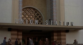 Movie still from “True Confessions” (1981), directed by Ulu Grosbard – People are walking in front of a union station entrance; Extreme Wide shot, Low angle