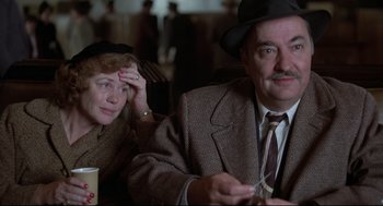 Movie still from “True Confessions” (1981), directed by Ulu Grosbard – An older man and woman sitting at a table; Close Up shot, Over the shoulder angle