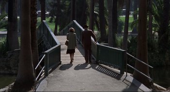 Movie still from “True Confessions” (1981), directed by Ulu Grosbard – A man and a woman walking across a bridge; Wide shot, High angle