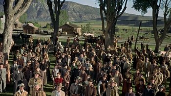 Movie still from “True Grit” (1969), directed by Henry Hathaway – A large group of people standing in a field; Extreme Wide shot, High angle