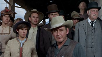 Movie still from “True Grit” (1969), directed by Henry Hathaway – A group of men in hats and vests standing next to each other; Medium shot, Low angle