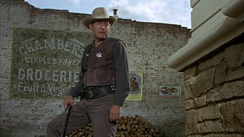 Movie still from “True Grit” (1969), directed by Henry Hathaway – A man in a cowboy hat holding a gun; Medium shot, Low angle