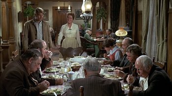 Movie still from “True Grit” (1969), directed by Henry Hathaway – A group of people sitting at a dinner table; Wide shot, High angle
