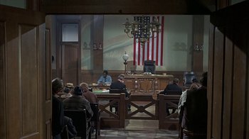 Movie still from “True Grit” (1969), directed by Henry Hathaway – A court room filled with people sitting at a table; Wide shot, High angle