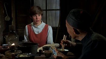 Movie still from “True Grit” (1969), directed by Henry Hathaway – Two people sitting at a table with chopsticks in front of them; Medium shot, Over the shoulder angle
