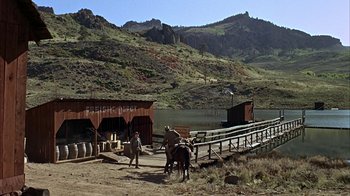 Movie still from “True Grit” (1969), directed by Henry Hathaway – A group of people riding horses near a body of water; Extreme Wide shot, High angle