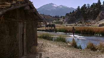 Movie still from “True Grit” (1969), directed by Henry Hathaway – A man standing on a river with horses; Extreme Wide shot, High angle