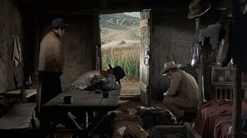 Movie still from “True Grit” (1969), directed by Henry Hathaway – A group of people in a room with a table and chairs; Wide shot, High angle