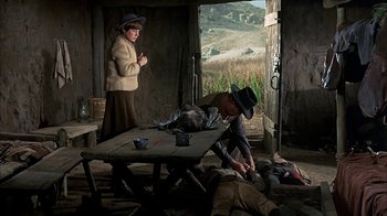Movie still from “True Grit” (1969), directed by Henry Hathaway – A man and a woman in a room with a table and chairs; Wide shot, High angle