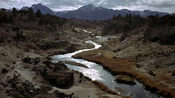 Movie still from “True Grit” (1969), directed by Henry Hathaway – A river running through the middle of a desert; Extreme Wide shot, High angle