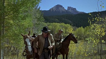 Movie still from “True Grit” (1969), directed by Henry Hathaway – Two men on horses in a field with mountains in the background; Wide shot, Low angle