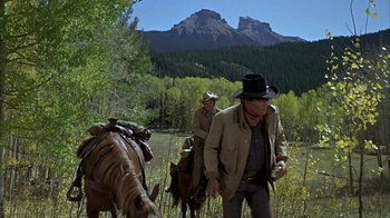 Movie still from “True Grit” (1969), directed by Henry Hathaway – Two men on horses in a field with mountains in the background; Wide shot, Low angle