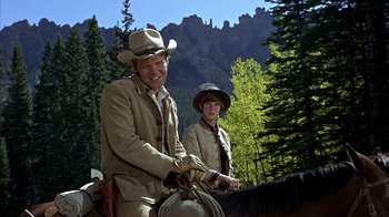Movie still from “True Grit” (1969), directed by Henry Hathaway – A man and a woman on a horse in the mountains; Medium shot, Low angle