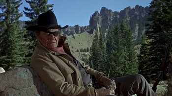 Movie still from “True Grit” (1969), directed by Henry Hathaway – An older man sitting on a horse in the mountains; Medium shot, Low angle