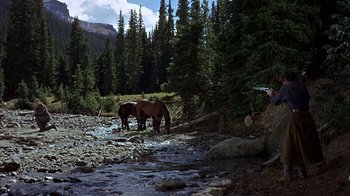 Movie still from “True Grit” (1969), directed by Henry Hathaway – A couple of horses are standing by a stream; Wide shot, High angle