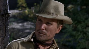 Movie still from “True Grit” (1969), directed by Henry Hathaway – A man with a cowboy hat and a brown jacket; Close Up shot, Low angle