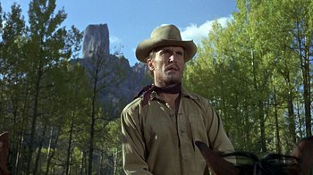 Movie still from “True Grit” (1969), directed by Henry Hathaway – A man with a hat and a bird in his hand; Medium shot, Low angle