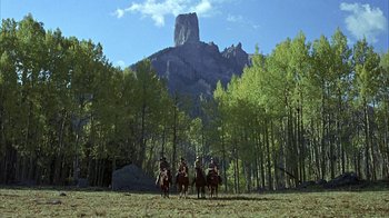 Movie still from “True Grit” (1969), directed by Henry Hathaway – A group of people riding horses in a field; Extreme Wide shot, Low angle