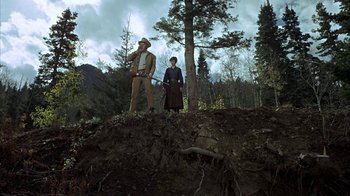 Movie still from “True Grit” (1969), directed by Henry Hathaway – A man and a woman standing on top of a hill; Wide shot, Low angle