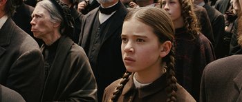 Movie still from “True Grit” (2010), directed by Ethan Coen – A young girl in a brown coat and braids; Close Up shot, High angle