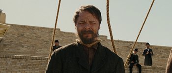 Movie still from “True Grit” (2010), directed by Ethan Coen – A man with a beard is hanging from a rope; Close Up shot, Over the shoulder angle