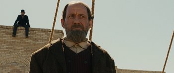 Movie still from “True Grit” (2010), directed by Ethan Coen – An old man with a beard and a bow tie; Close Up shot, Low angle