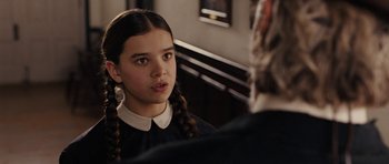 Movie still from “True Grit” (2010), directed by Ethan Coen – A young girl in a school uniform talking to an older person; Close Up shot, Over the shoulder angle