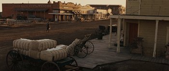 Movie still from “True Grit” (2010), directed by Ethan Coen – An old wagon sitting on top of a wooden deck; Extreme Wide shot, High angle