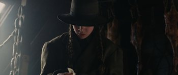 Movie still from “True Grit” (2010), directed by Ethan Coen – A woman in a hat is holding a piece of paper in her hands; Close Up shot, Low angle