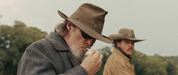 Movie still from “True Grit” (2010), directed by Ethan Coen – A man with a beard wearing a cowboy hat; Close Up shot, Low angle