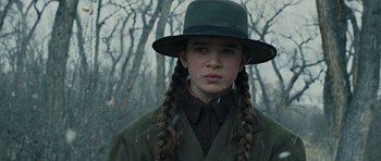Movie still from “True Grit” (2010), directed by Ethan Coen – A young girl in a green hat and a green coat; Close Up shot, Low angle