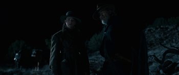 Movie still from “True Grit” (2010), directed by Ethan Coen – A man and a woman standing next to each other in the dark; Medium shot, Over the shoulder angle