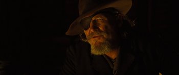 Movie still from “True Grit” (2010), directed by Ethan Coen – A man with a beard wearing a cowboy hat and eye patch; Close Up shot, Over the shoulder angle