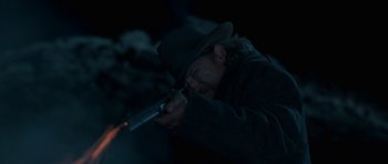 Movie still from “True Grit” (2010), directed by Ethan Coen – A man in a hat is holding a gun; Close Up shot, Over the shoulder angle