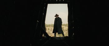 Movie still from “True Grit” (2010), directed by Ethan Coen – A man standing in an open doorway of an old building; Wide shot, Low angle