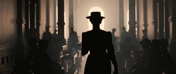 Movie still from “True Grit” (2010), directed by Ethan Coen – A woman wearing a hat walking through a hallway; Wide shot, Over the shoulder angle