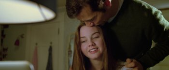Movie still from “Trust” (2010), directed by David Schwimmer – A man kissing a woman's forehead while she looks at the camera; Close Up shot, Low angle