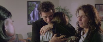 Movie still from “Trust” (2010), directed by David Schwimmer – A man and a woman hugging in a living room; Medium shot, Over the shoulder angle