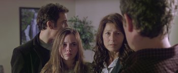 Movie still from “Trust” (2010), directed by David Schwimmer – A group of people standing next to each other in a room; Close Up shot, Over the shoulder angle