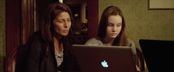 Movie still from “Trust” (2010), directed by David Schwimmer – A woman sitting next to another woman on a laptop; Medium shot, Over the shoulder angle