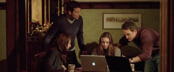 Movie still from “Trust” (2010), directed by David Schwimmer – A man and two women looking at a laptop; Medium shot, High angle