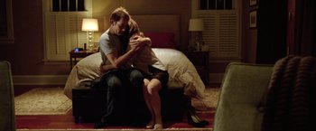 Movie still from “Trust” (2010), directed by David Schwimmer – A man and a woman sitting on a bed hugging; Medium shot, High angle